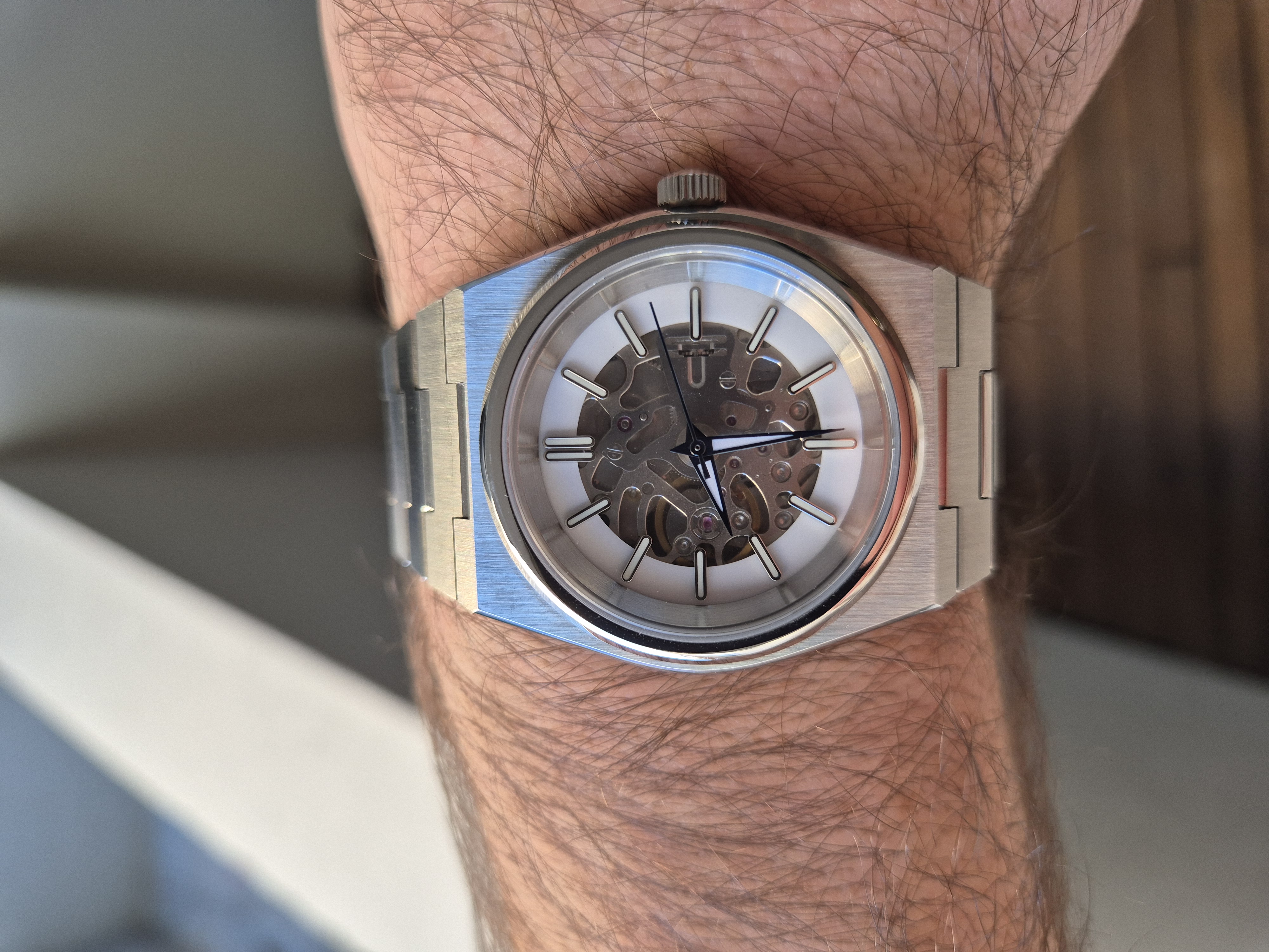 A finished NH70 skeleton watch on the wrist — gear train visible through the dial